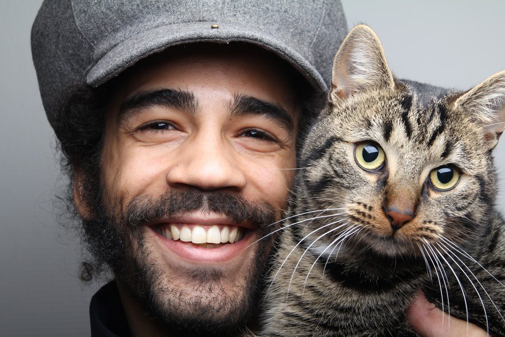 smiling pet owner with his happy cat